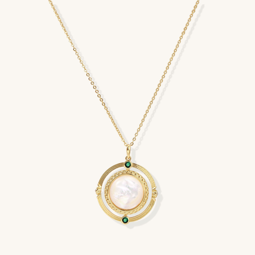 Gold-plated pendant necklace with circular orbital design, iridescent mother-of-pearl center and green zirconia accents